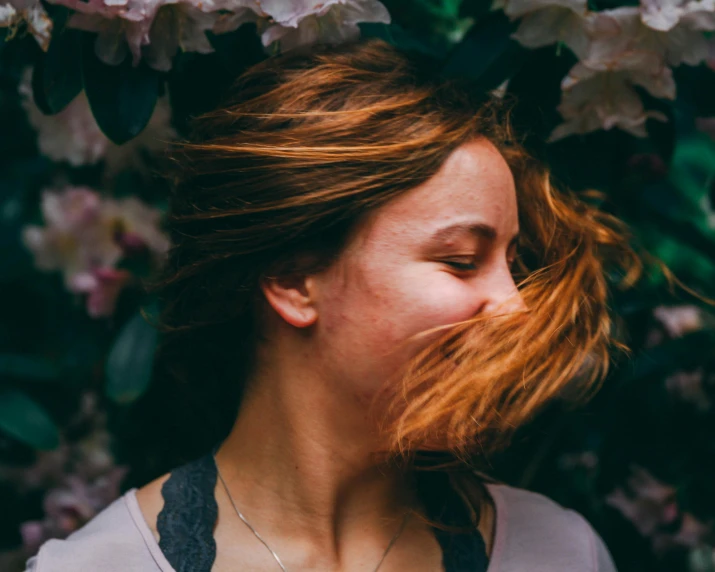 a woman that is wearing flowers around her face