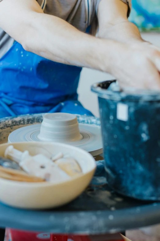 a man is painting on the wheel of a pottery wheel