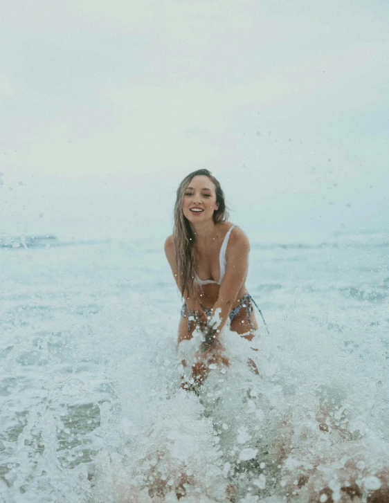 a woman stands in the ocean surrounded by water