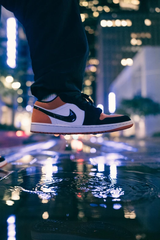 man in blue and brown sneakers jumping over an object in the dark