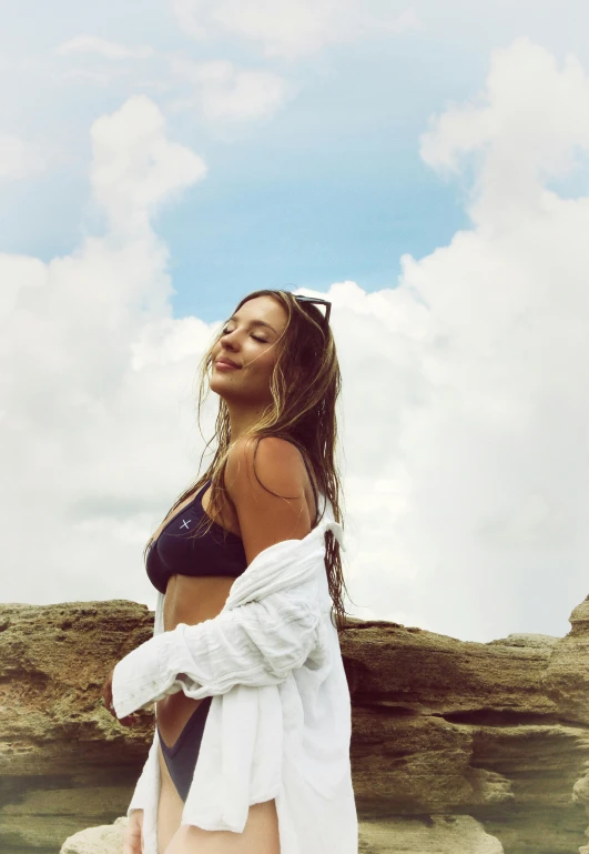 a woman is posing for the camera, wearing sunglasses and a black bikini