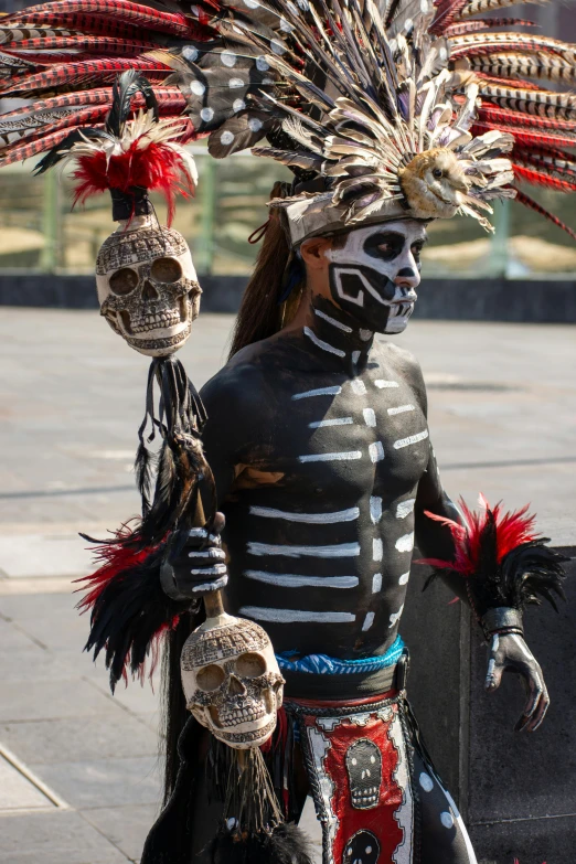 a skeleton face makeup sits with several colorful mask ornaments