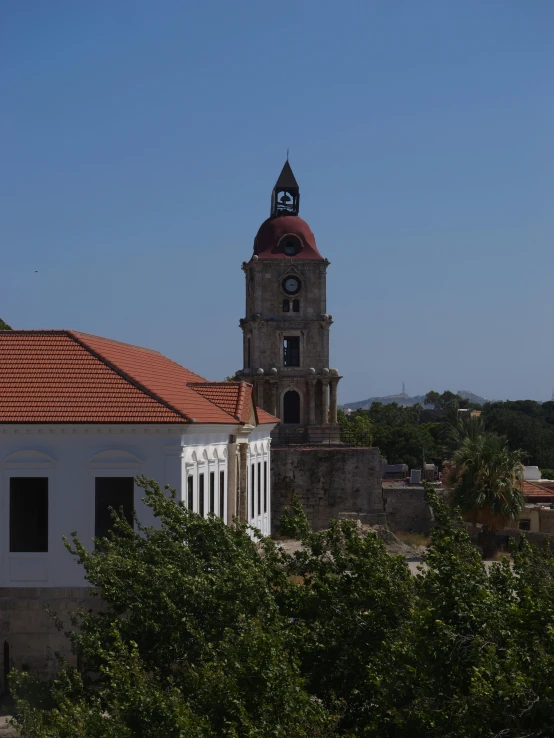 there is a church tower and trees near by