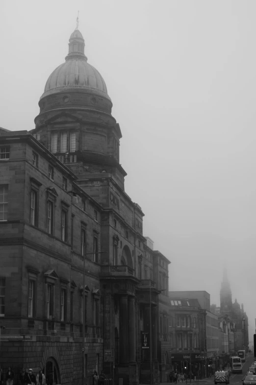 old buildings are in the fog in front of a large church