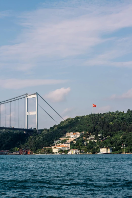 a large bridge is near the hills on a sunny day