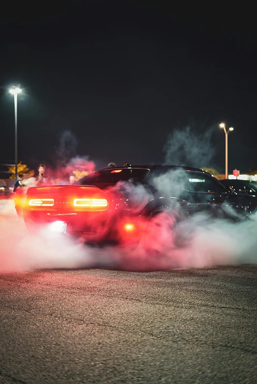 a person driving a car down a street with smoke pouring from its back