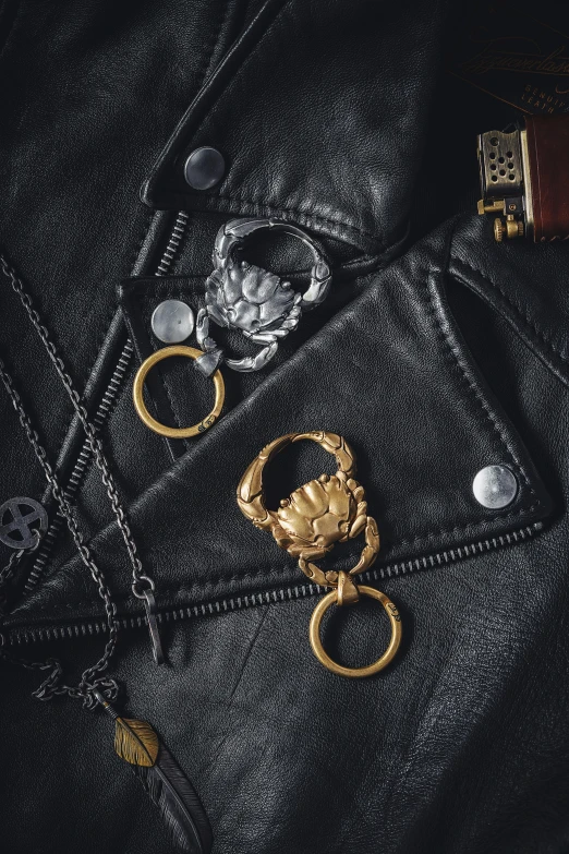 various gold accessories layed on top of a black jacket