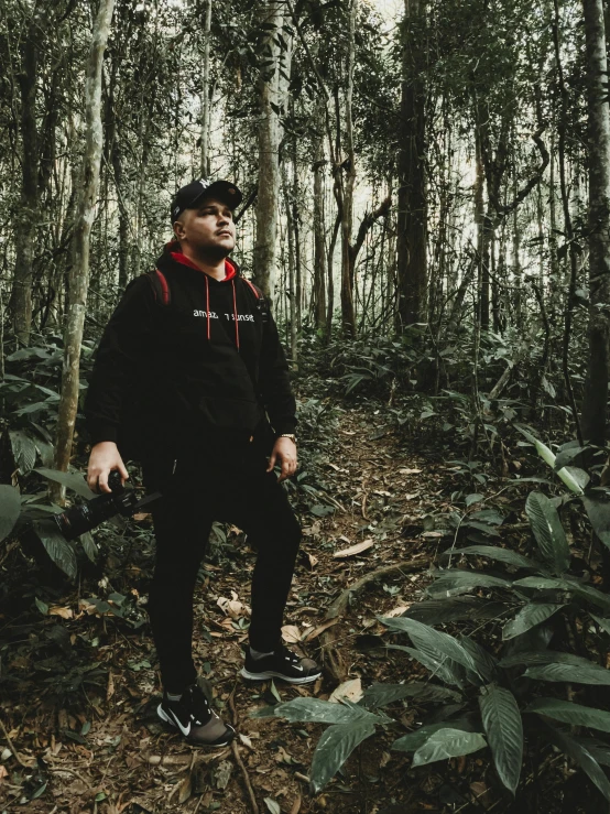 man sitting in the middle of a forest alone