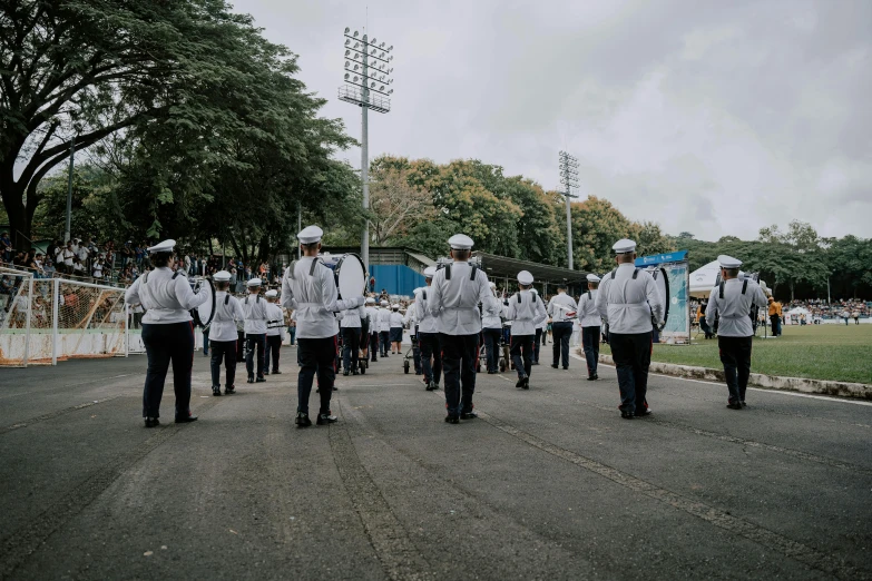 a marching band standing on top of a dirt ground