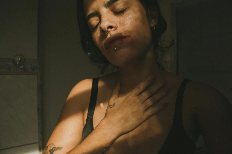 a woman is sitting down with her hands crossed in front of her chest