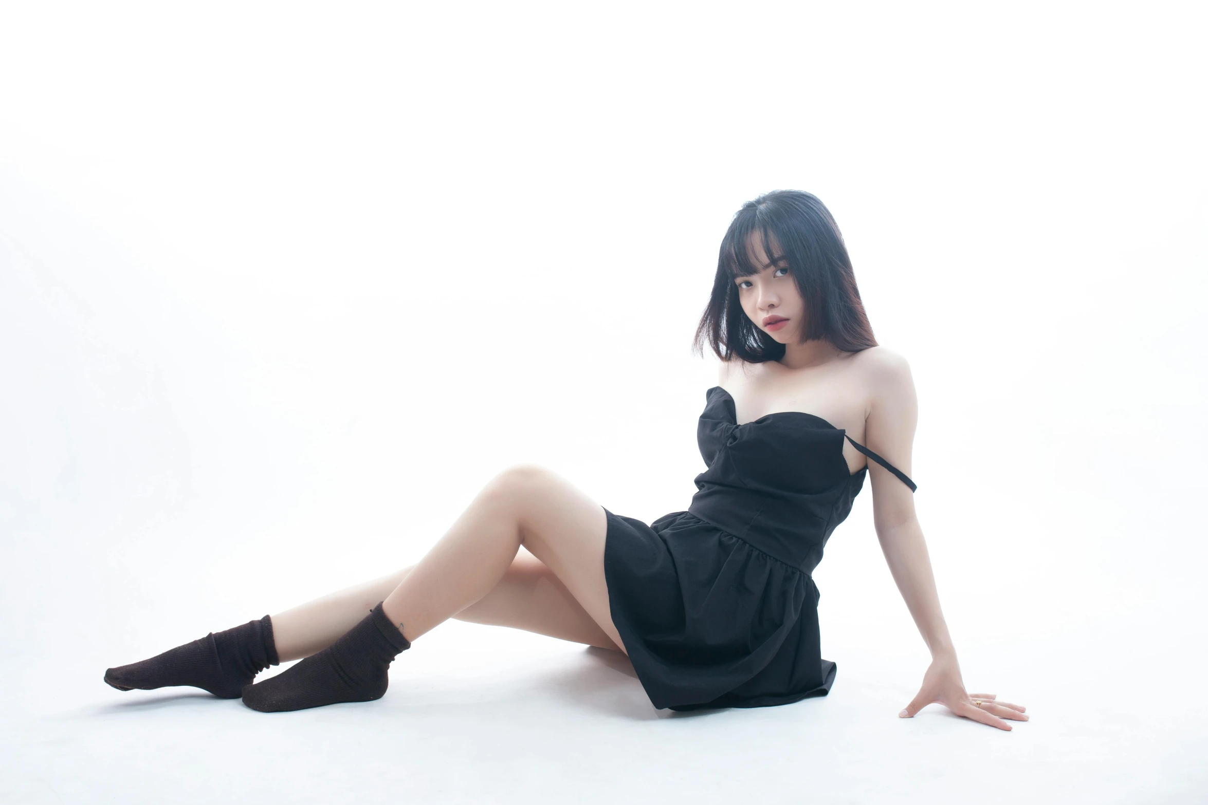 asian woman in black dress sitting on white background