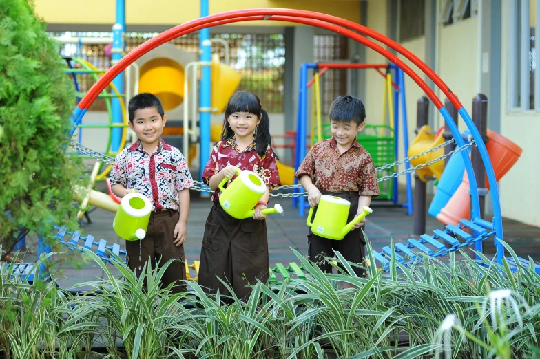 three children posing in front of a playground