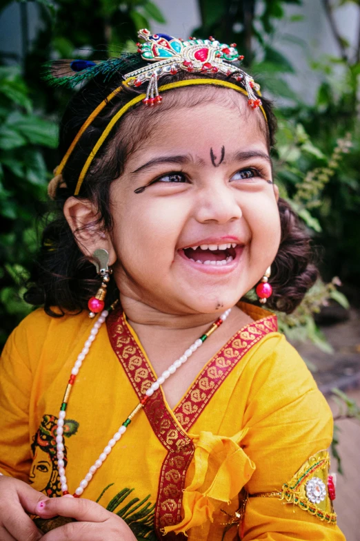 a child wearing some head jewelry with her tongue out