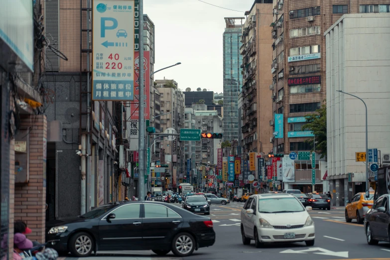 a city street in an asian country has cars and buildings