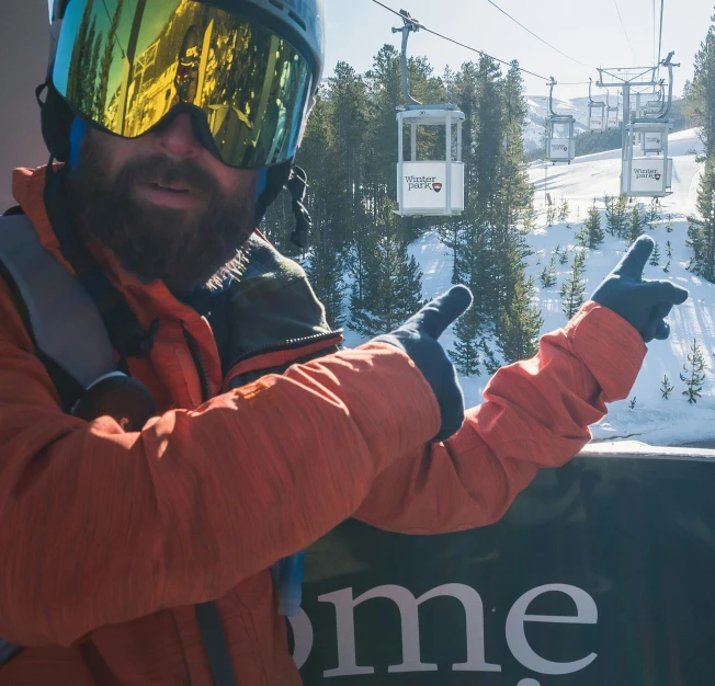 a man pointing to the gondola from his chair lift