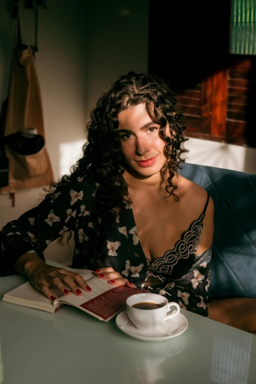 a woman sits in a chair while looking at a book