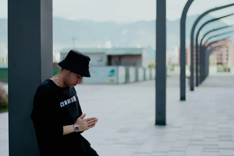 a man sitting on top of a black pole