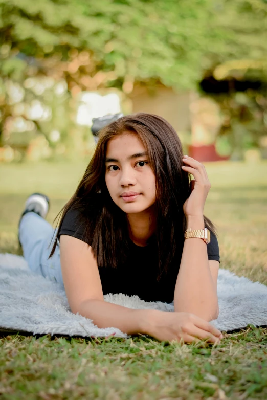 young woman lying down on a blanket in the park