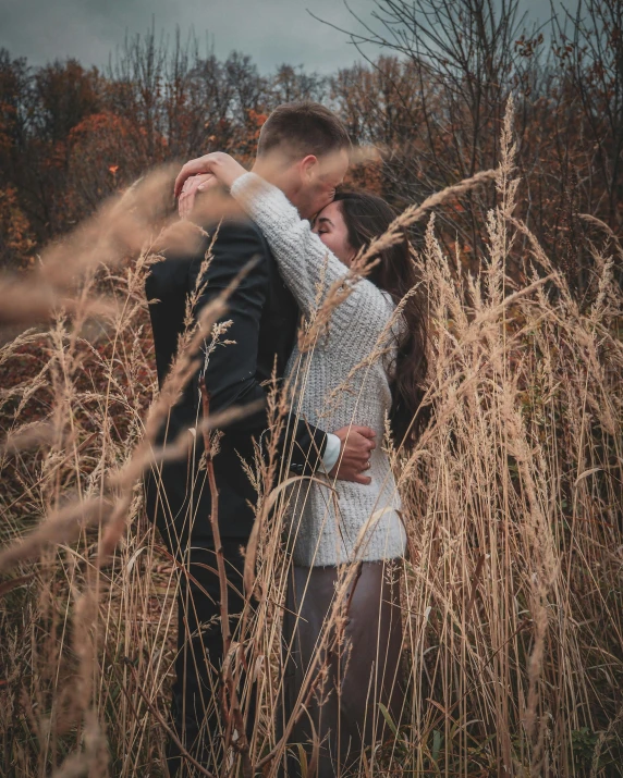 a young couple cuddling under a gray sky