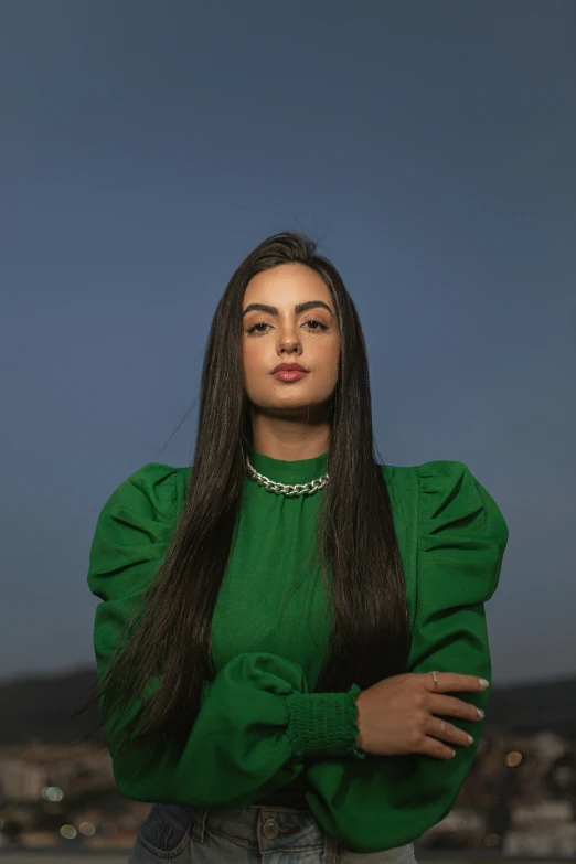 a young woman with long hair wearing a green top