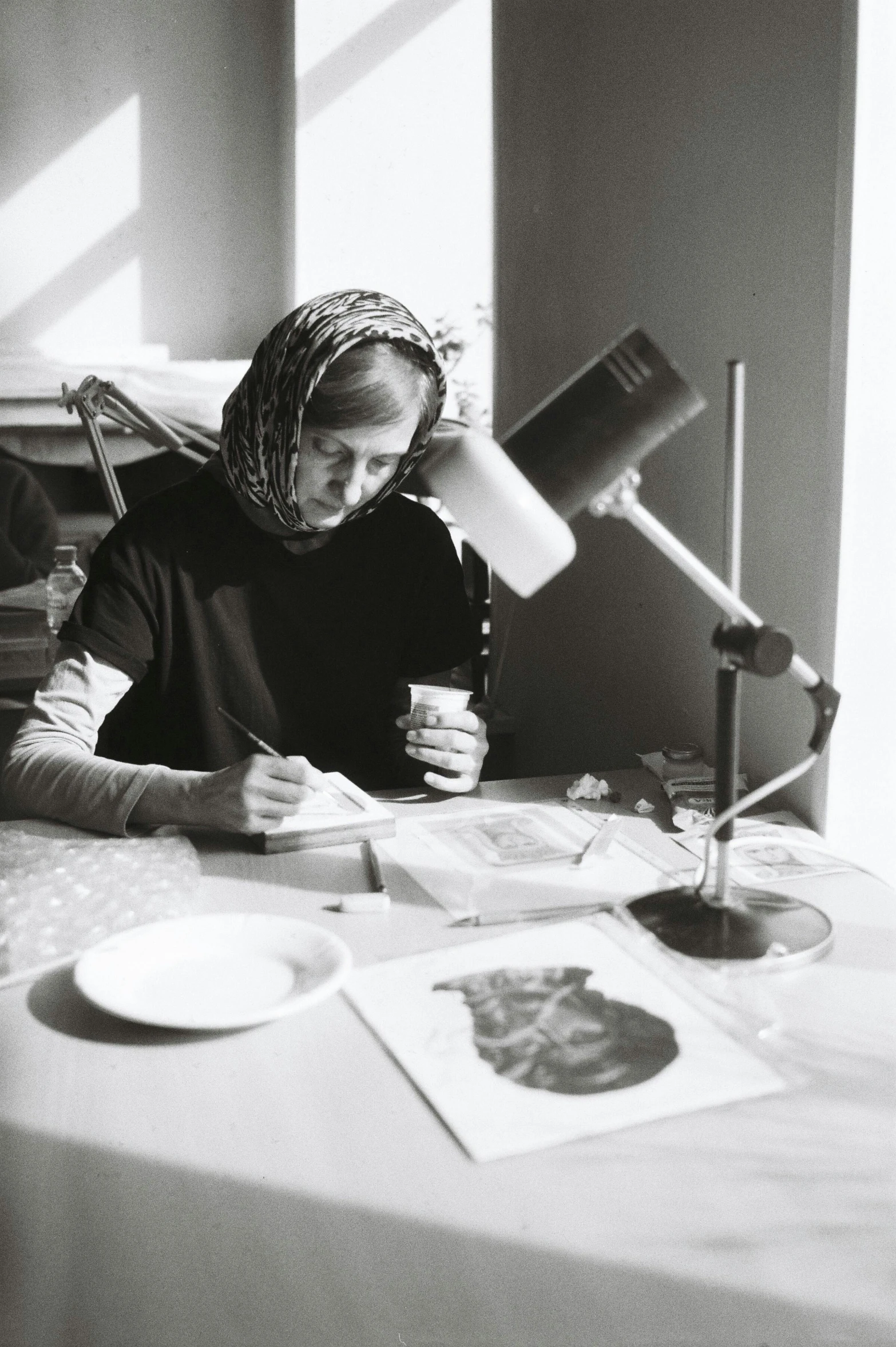 a woman sitting at a table with a cup