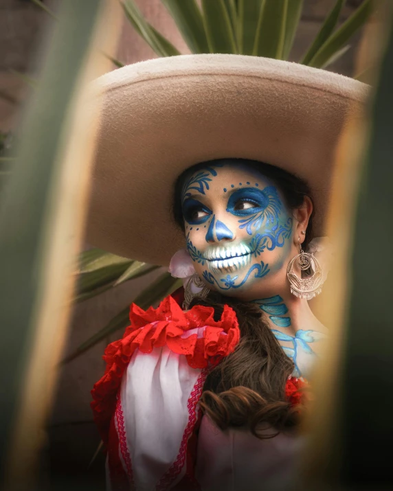 a woman with blue painted face is wearing a mexican costume