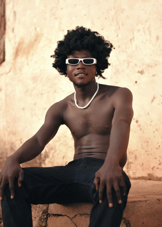 a young man sitting on top of a wall