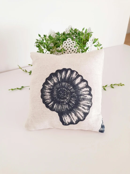 a white pillow with a black flower on the front of it