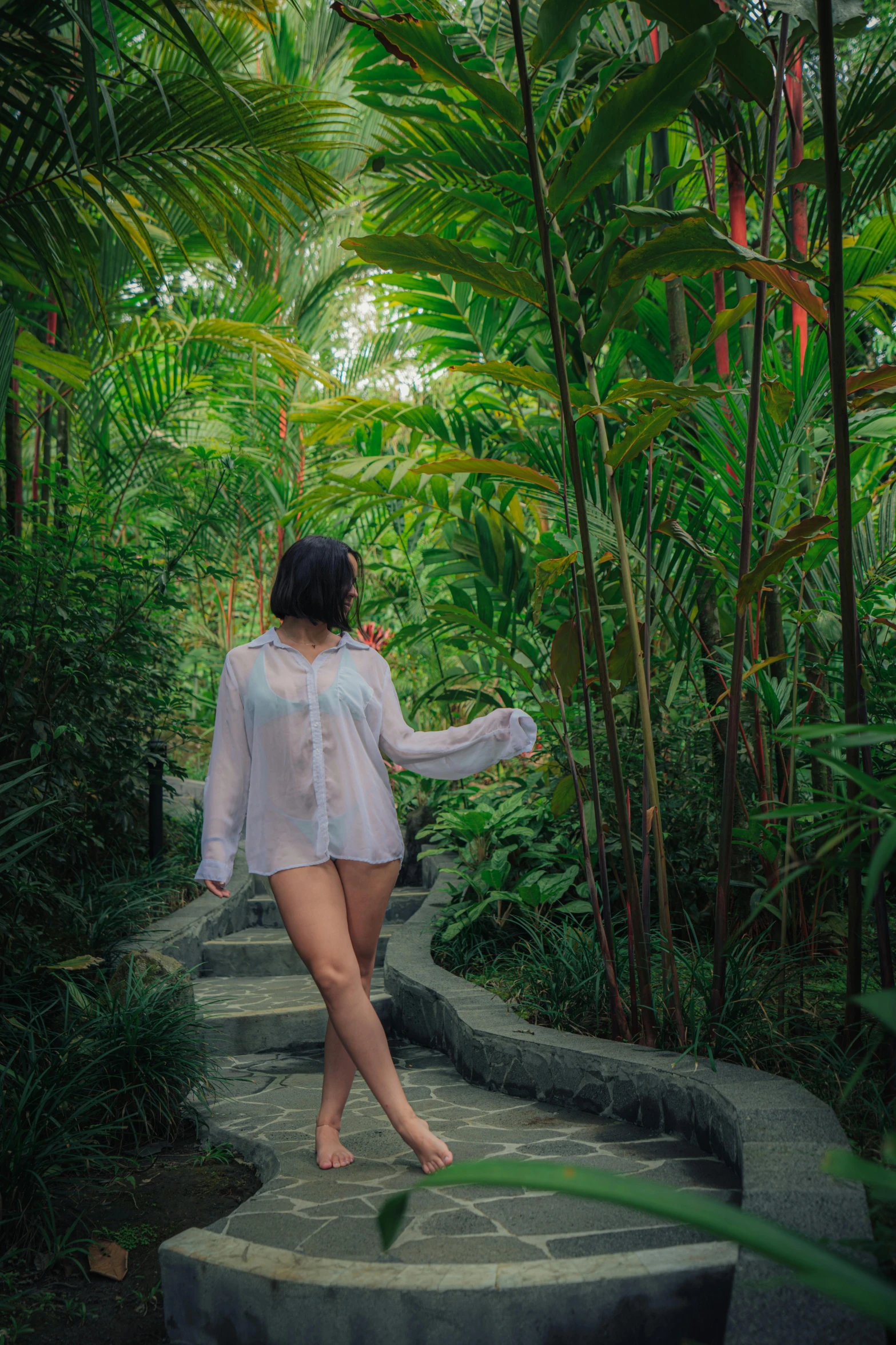 there is a woman standing on the stairs in the jungle