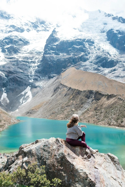 girl looking at large mountain range with lake and mountains in background