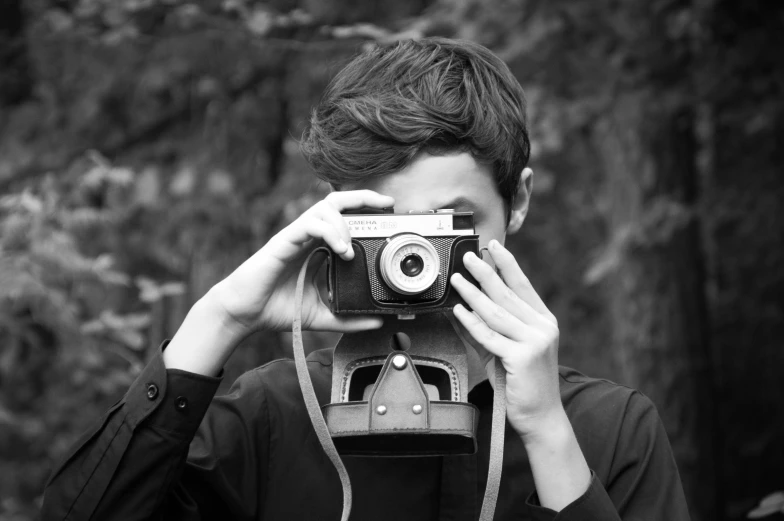 a boy looking through an old camera