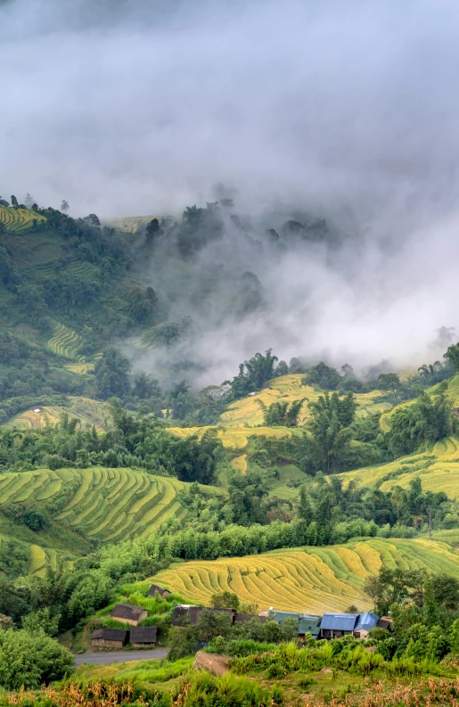 a small village sits in a large open field with mountains