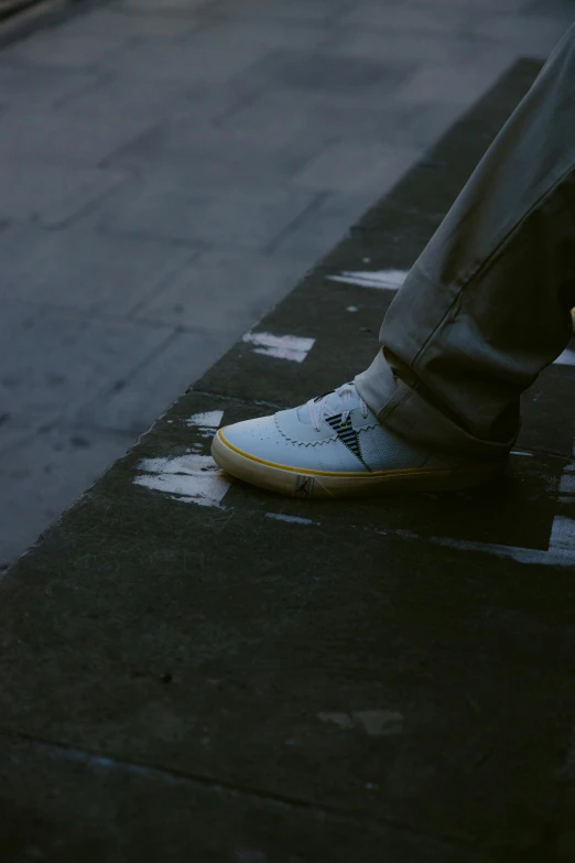 the feet of someone walking down a street on a sidewalk