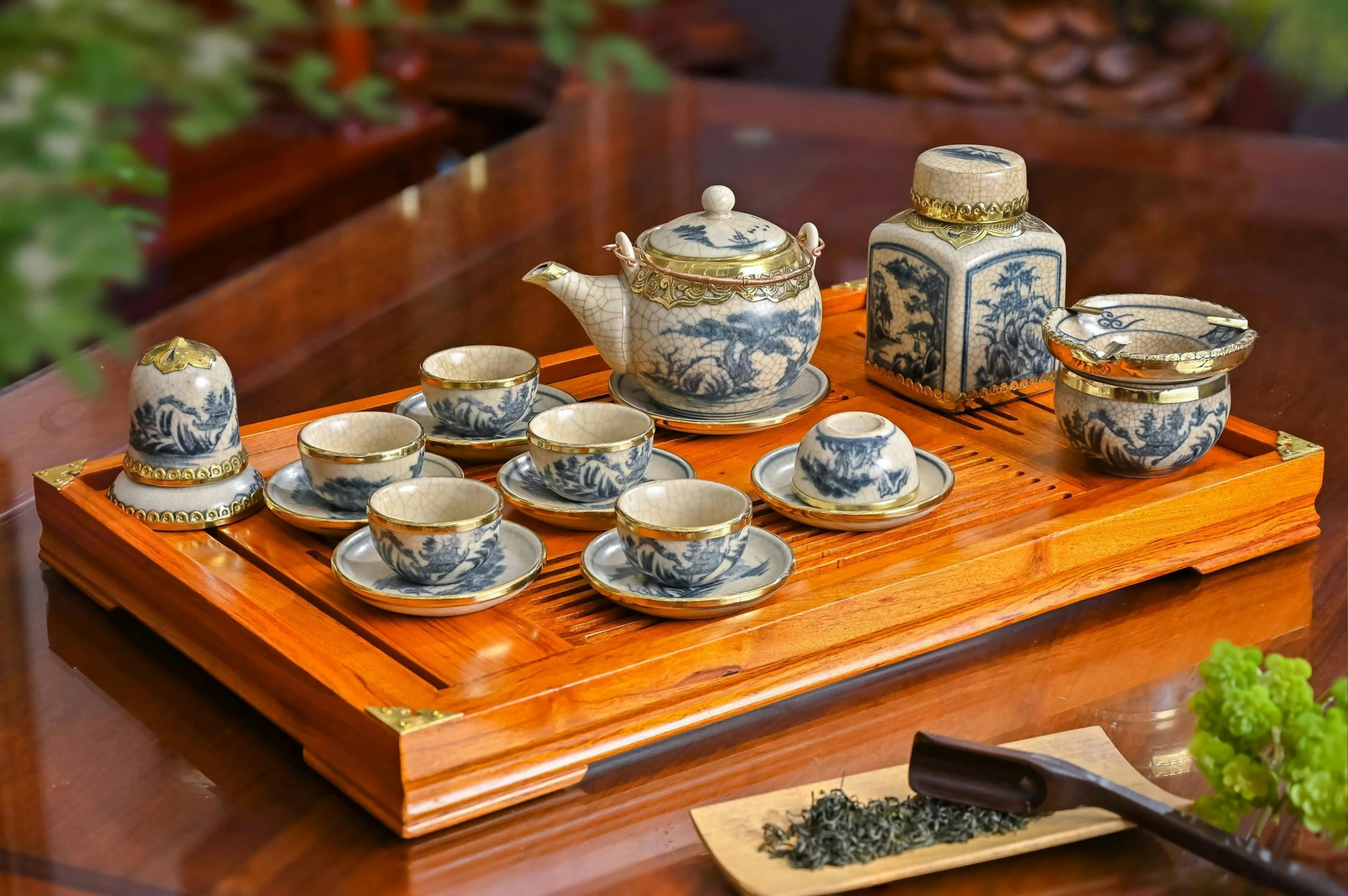 a wood tray holding several teacups and cups