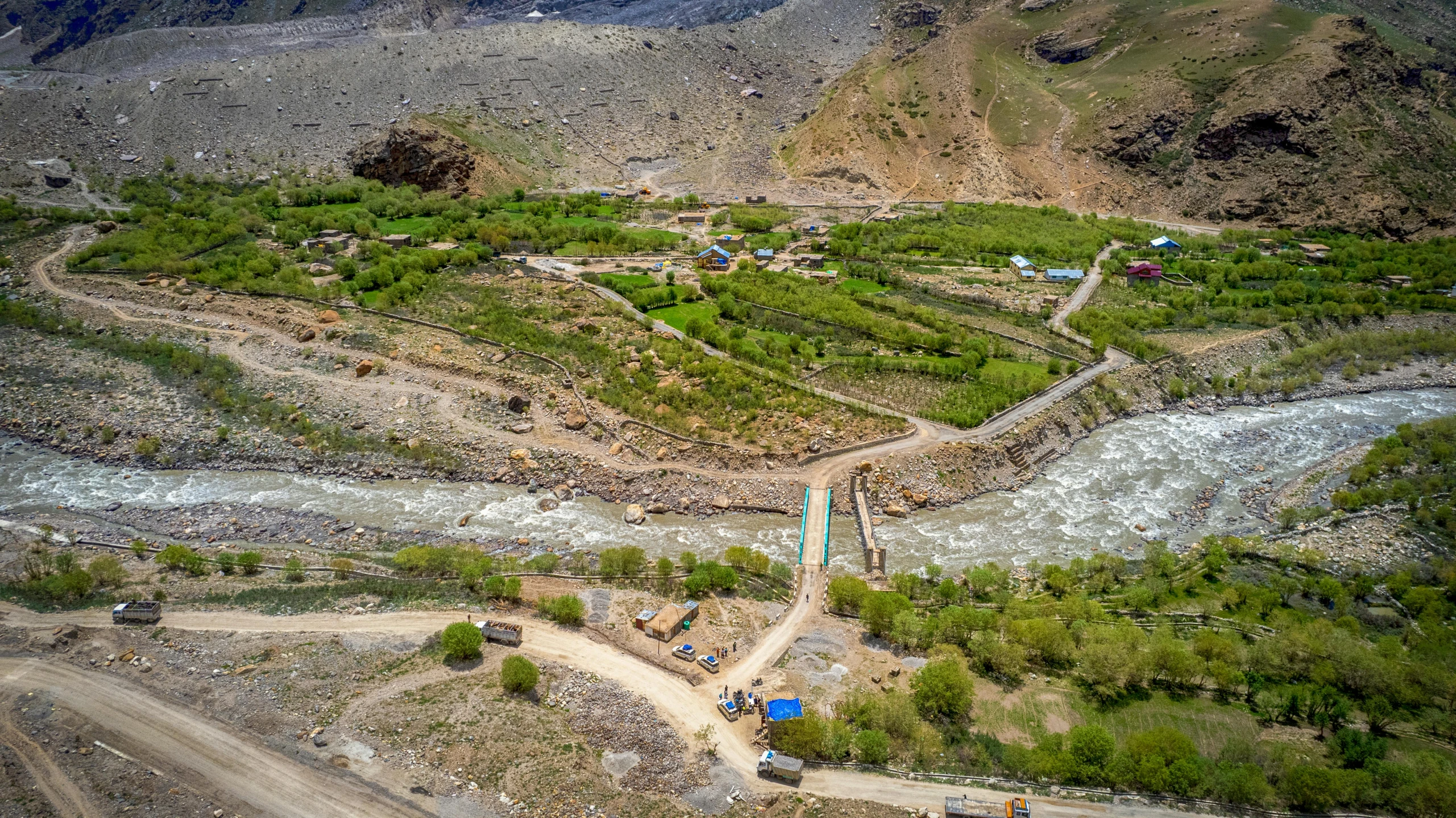 a picture from a helicopter showing the river, mountains and farm