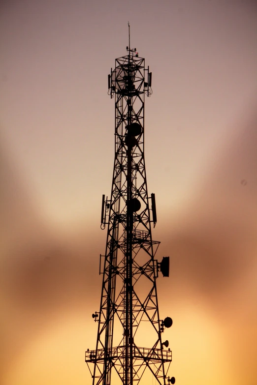 a radio tower stands tall against the sun