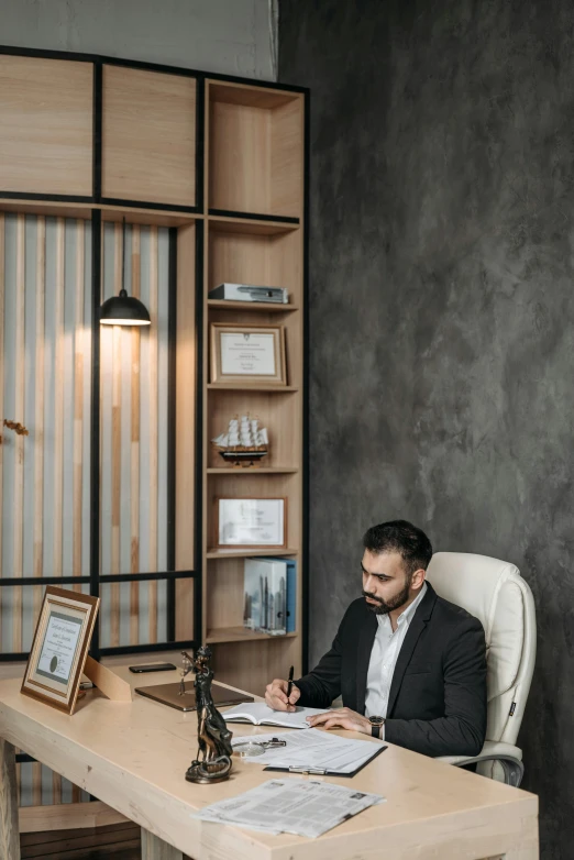 an office worker writing at his desk with a framed picture on the desk