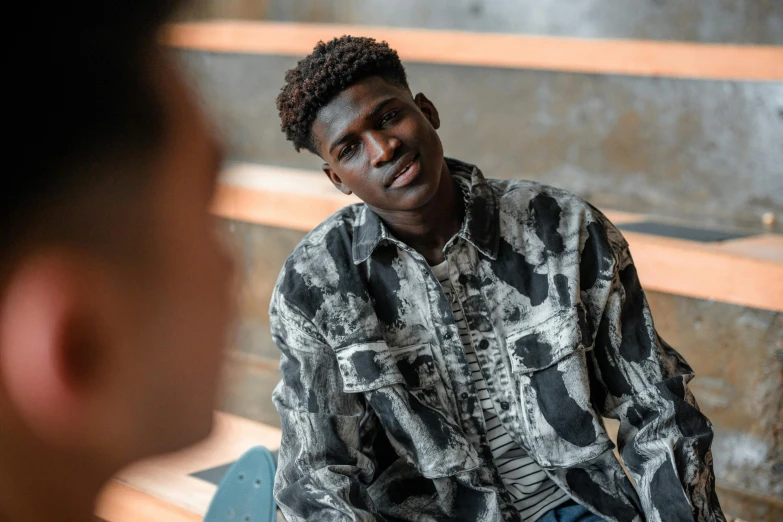 an african american man smiling as he sits on a bench