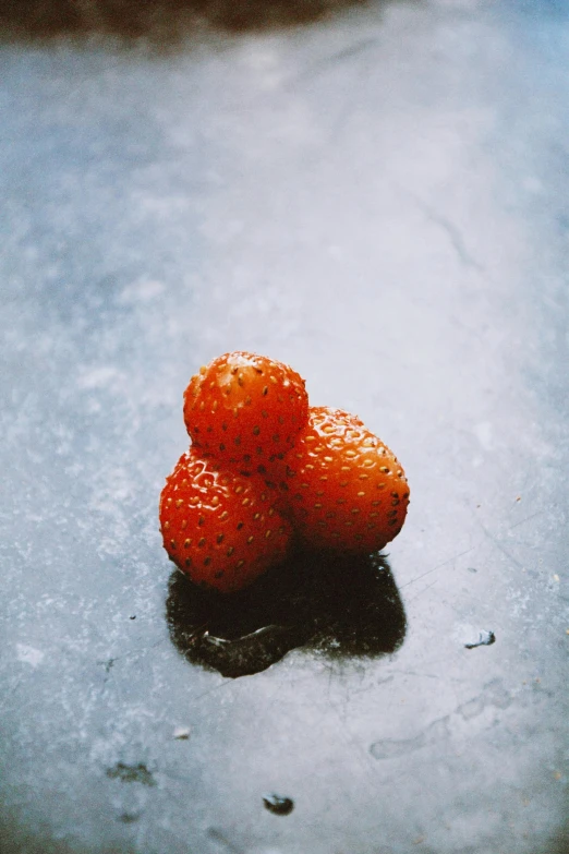 there is three oranges on the surface of the table