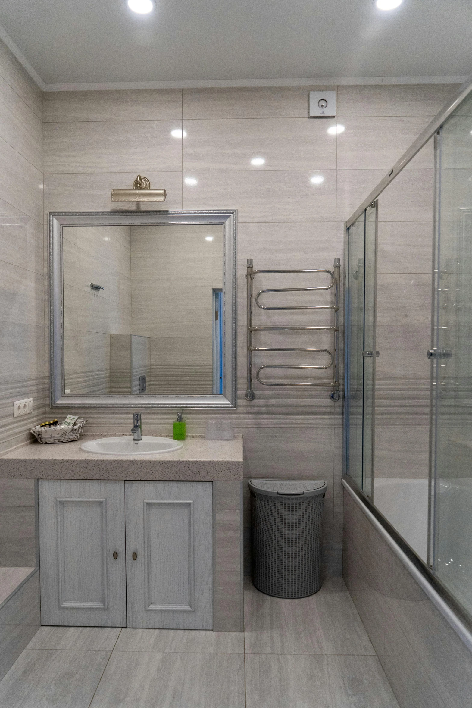 an empty bathroom has white cabinets and marble flooring