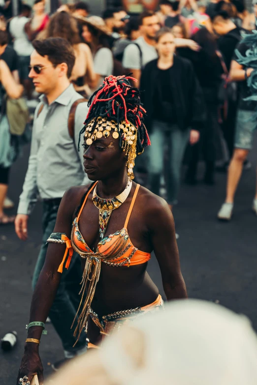 a man wearing head dress walking with people standing behind him