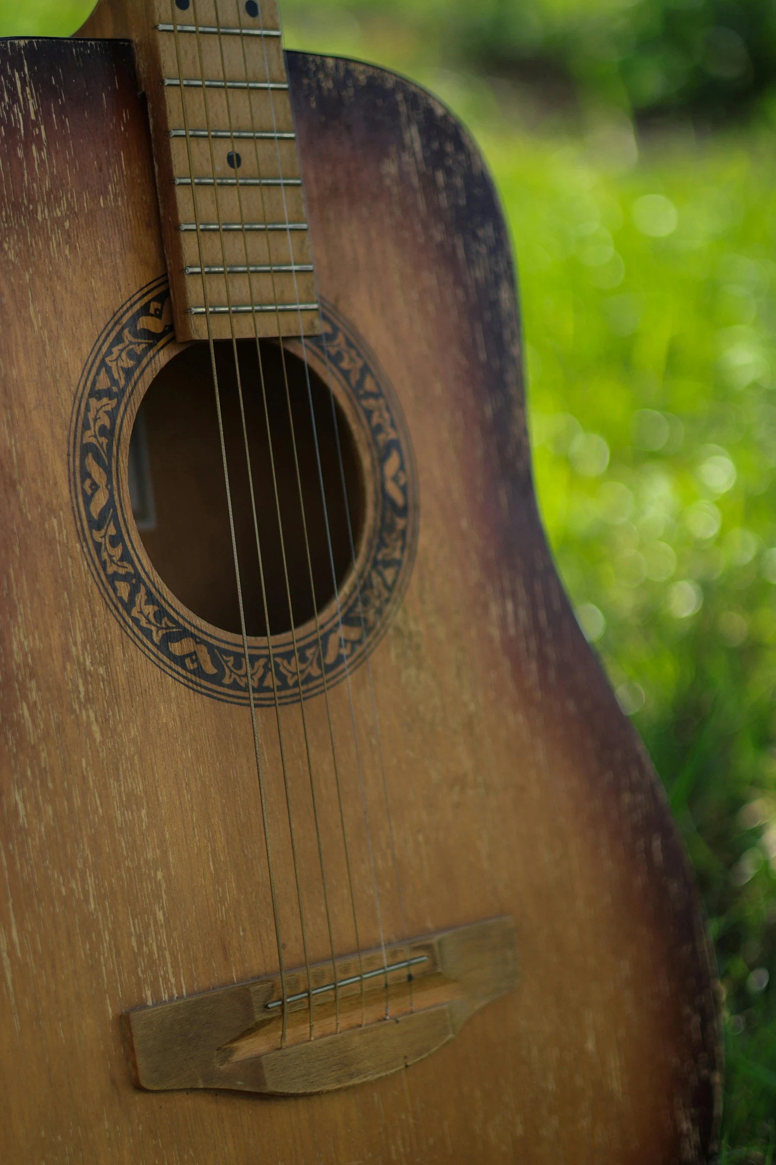 a close up of an acoustic guitar on grass