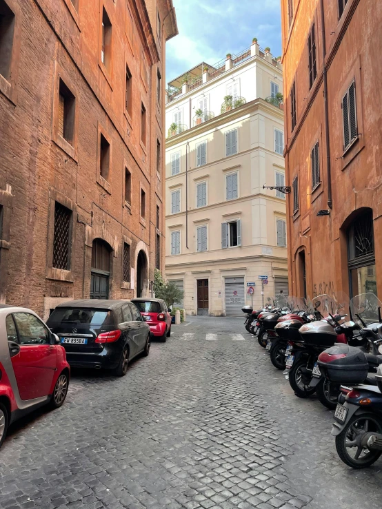 some cars a motorcycle and a lot of buildings