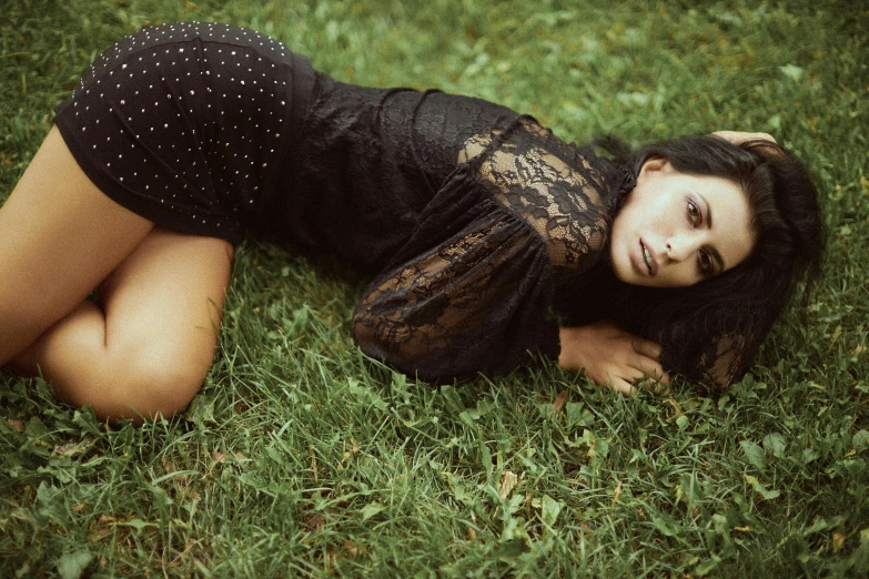 a woman is laying in the grass looking sad