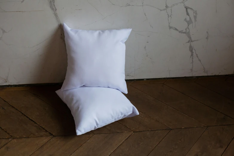 a white pillow sitting on top of a wooden floor