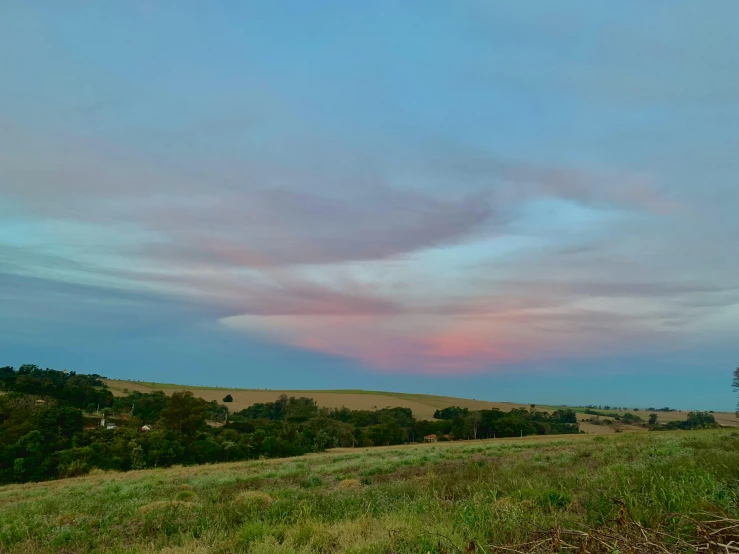 clouds are over a grassy plain on a cloudy day