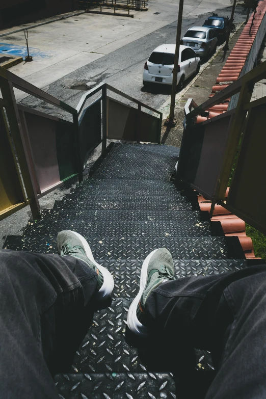 a person sitting down on the steps looking down