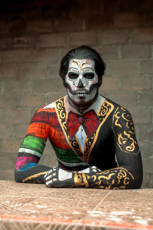 a man in a colorful shirt sits on a stone counter