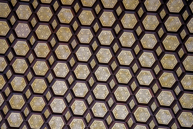 the ceiling is made up of square gold and black tiles