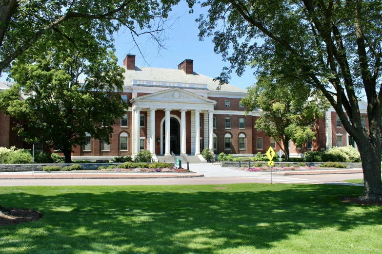 a building with columns and a white door under a tree